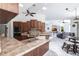 Modern kitchen boasts wood cabinetry, an island with a sink, and access to the living room and dining room at 25179 Campos Dr, Punta Gorda, FL 33983
