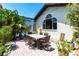 Brick patio with a table surrounded by lush landscaping at 25179 Campos Dr, Punta Gorda, FL 33983