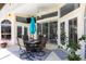 A covered patio featuring an outdoor dining set, ceiling fan, and access to the home's interior at 25179 Campos Dr, Punta Gorda, FL 33983