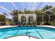Beautiful pool with surrounding landscaping under a screen, creating a private oasis at 25179 Campos Dr, Punta Gorda, FL 33983