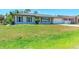 Inviting single-story home with a well-manicured lawn and gray shutters at 309 Aurora St, Port Charlotte, FL 33948