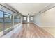 Bright living room featuring wood floors, fan, and sliding glass doors to the screened patio at 309 Aurora St, Port Charlotte, FL 33948