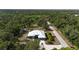 View of home from above the trees, showcasing metal roof, garage, and surrounding landscape at 3136 Joshua St, Port Charlotte, FL 33948