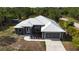 Aerial view showcasing the home's metal roof, landscaping, and attached garage at 3136 Joshua St, Port Charlotte, FL 33948