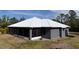 Rear exterior showcasing the home's screened patio and durable metal roof at 3136 Joshua St, Port Charlotte, FL 33948