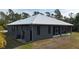 Rear exterior showcasing the home's screened patio and durable metal roof at 3136 Joshua St, Port Charlotte, FL 33948