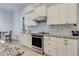 Stylish kitchen featuring white cabinets, granite countertops, stainless steel appliances, and modern finishes at 3136 Joshua St, Port Charlotte, FL 33948