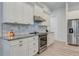 Well-lit kitchen featuring white cabinets, stainless steel appliances, and granite countertops at 3136 Joshua St, Port Charlotte, FL 33948