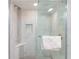 Contemporary walk-in shower features a glass door, a rain-style shower head, and a built-in seat at 3221 White Ibis Ct # D2, Punta Gorda, FL 33950