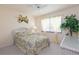 A cozy bedroom with floral-themed bedding, decorative curtains and wicker furniture at 3221 White Ibis Ct # D2, Punta Gorda, FL 33950