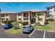 A two story tan condo shows green grass, landscaping, balconies, and parking spaces at 3221 White Ibis Ct # D2, Punta Gorda, FL 33950