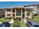 A two story tan condo showcases well-maintained landscaping, two parked cars, and balconies at 3221 White Ibis Ct # D2, Punta Gorda, FL 33950