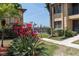 Exterior view showcasing lush landscaping and a glimpse of the community pool, highlighting the building's curb appeal at 3221 White Ibis Ct # D2, Punta Gorda, FL 33950