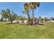 Expansive green backyard featuring mature trees and a charming white picket fence at 3305 Blue Jay Ln, Englewood, FL 34224
