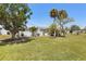 Spacious backyard featuring mature trees and a charming white picket fence at 3305 Blue Jay Ln, Englewood, FL 34224