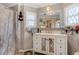 Bright bathroom with a white vanity featuring mirrored doors, stylish fixtures and a framed mirror at 3305 Blue Jay Ln, Englewood, FL 34224