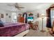 Relaxing bedroom featuring a ceiling fan, decorative accents, and a view of the ensuite bathroom at 3305 Blue Jay Ln, Englewood, FL 34224