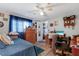 Comfortable bedroom with a ceiling fan, wood-look flooring and closet access at 3305 Blue Jay Ln, Englewood, FL 34224
