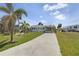 Well-manicured lawn and landscaping with a driveway leading to a single story home with car port at 3305 Blue Jay Ln, Englewood, FL 34224
