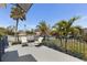 Inviting patio with seating and charming blue railings, surrounded by lush palm trees at 3305 Blue Jay Ln, Englewood, FL 34224