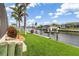 Waterfront backyard features lush landscaping and access to a canal, perfect for boating and enjoying the serene water views at 340 Belaire Ct, Punta Gorda, FL 33950