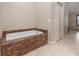 Neutral bathroom featuring a soaking tub with granite surround, tile floors and a white door at 340 Belaire Ct, Punta Gorda, FL 33950
