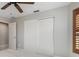 Neutral bedroom featuring a fan, plantation shutters, and a closet with sliding doors at 340 Belaire Ct, Punta Gorda, FL 33950