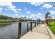 A dock along the canal that offers a boat lift, concrete pathway, and luscious green landscaping at 340 Belaire Ct, Punta Gorda, FL 33950