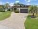 Inviting home features a brick driveway, well-kept lawn, and mature palm trees, enhancing its curb appeal at 340 Belaire Ct, Punta Gorda, FL 33950