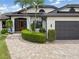 Beautiful single-Gathering house with a two-car garage, manicured hedges, a brick driveway, and mature landscaping at 340 Belaire Ct, Punta Gorda, FL 33950