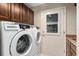 Well-equipped laundry room features a front-load washer and dryer, ample cabinet space, and a convenient exterior door at 340 Belaire Ct, Punta Gorda, FL 33950