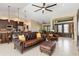 Spacious living room with tile floors, leather furniture, and modern ceiling fan at 340 Belaire Ct, Punta Gorda, FL 33950