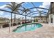 Tranquil pool with a screened-in enclosure surrounded by mature landscaping at 340 Belaire Ct, Punta Gorda, FL 33950