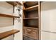 Custom walk-in closet with wooden shelves, drawers, and metal basket for plenty of storage at 340 Belaire Ct, Punta Gorda, FL 33950
