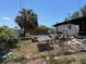 Damaged backyard with overgrown grass, debris, and a burnt fence after a fire at 3538 Pinetree St, Port Charlotte, FL 33952