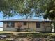 Exterior shot of the back of the home with white siding and multiple windows on an overgrown lot at 3538 Pinetree St, Port Charlotte, FL 33952