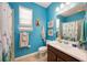 Bright bathroom featuring blue walls, a single vanity, and a shower/tub combo at 3664 Tin Cup Blvd, Sarasota, FL 34232