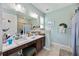 Bathroom with a dual sink vanity, tile floors, and soft blue walls at 3664 Tin Cup Blvd, Sarasota, FL 34232