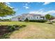 Inviting single-story home with manicured lawn and lush landscaping, showcasing curb appeal under a sunny sky at 3664 Tin Cup Blvd, Sarasota, FL 34232