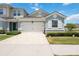 Townhome showcasing a two-car garage with a brick-paved driveway and meticulously maintained landscaping at 3664 Tin Cup Blvd, Sarasota, FL 34232