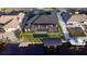Aerial view of a waterfront home with a screened in patio and a boat lift on the canal at 3729 Peace River Dr, Punta Gorda, FL 33983