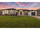 New construction home with black trim, modern design, three car garage, and fresh green lawn at 3729 Peace River Dr, Punta Gorda, FL 33983