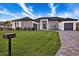 Stunning modern home with lush green lawn, beautiful landscaping, a paved driveway, and contrasting white and gray exterior at 3729 Peace River Dr, Punta Gorda, FL 33983