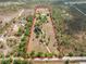Expansive aerial view of a large lot with a defined red boundary and a few structures and mature trees at 47350 Bermont Rd, Punta Gorda, FL 33982