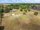 Aerial view of sprawling acreage with a single-story house, a detached garage, and verdant trees dotting the landscape at 47350 Bermont Rd, Punta Gorda, FL 33982