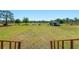 View from screened porch across large backyard with utility shed/workshop, and fencing in the distance at 47350 Bermont Rd, Punta Gorda, FL 33982