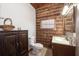 Bathroom featuring rustic wood paneling and a modern vanity at 47350 Bermont Rd, Punta Gorda, FL 33982