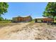 Ranch-style wooden home featuring a covered porch, a detached garage, and surrounded by a spacious, grassy yard at 47350 Bermont Rd, Punta Gorda, FL 33982