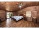 Warm and inviting main bedroom with a king-size bed, wood-paneled walls, hardwood floors, and a ceiling fan at 47350 Bermont Rd, Punta Gorda, FL 33982