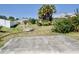 Backyard concrete slab and overgrown bushes with view of neighboring houses at 5050 Prosch Cir, North Port, FL 34288
